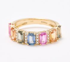 an 18k yellow gold ring set with multi - colored sapphires and diamond accents