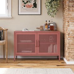 a red cabinet sitting next to a brick wall