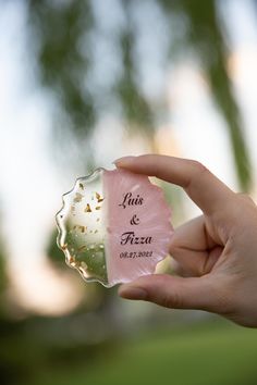 a person holding up a piece of glass with the words love and pizza on it