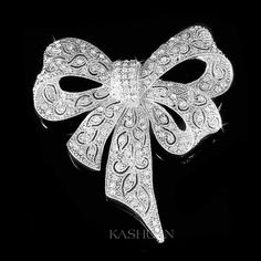 "PERFECT GIFT /WEDDING GIFT FOR BRIDE / GROOM / BRIDESMAID / LADY! Great Accent for your Wedding Dress! This sparkling Large Meticulous Bow Brooch made with tons of Swarovski crystals measuring 2 1/2\" wide X 2 5/8\" high (65mm X 68mm). Crystal Color: Crystal Clear Great piece for your collection! Prices are in US$. For shipping policies and other important information, click on \"profile\" on the right. See an item that you like but has already been sold? Contact me to see if I have more! Thank White Jewelry With Decorative Bow For Wedding, White Decorative Bow Jewelry For Wedding, White Wedding Jewelry With Decorative Bow, Silver Jewelry With Decorative Bow For Wedding, Elegant Silver Brooch For Christmas, Silver Wedding Jewelry With Decorative Bow, Glamorous Wedding Jewelry With Bow, White Ribbon Brooch For Wedding, Wedding Jewelry With Rhinestones For Christmas