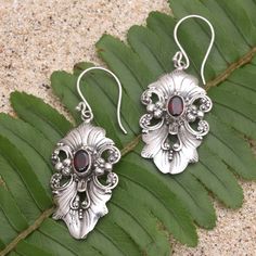 Elaborate and elegant Giri Tasmana's dangle earrings are perfect for a fancy dinner party. The Balinese artisan uses sterling silver to hand craft the floral motif centering each earring with a faceted garnet stone for an unexpected pop of radiant color. Elegant Garnet Drop Earrings, Elegant Garnet Earrings, Artisan Sterling Silver Chandelier Earrings For Gift, Ornate Sterling Silver Chandelier Earrings As Gift, Formal Dangle Garnet Earrings, Elegant Red Chandelier Earrings With Intricate Design, Formal Garnet Dangle Earrings, Elegant Pierced Garnet Earrings, Elegant Silver Garnet Earrings