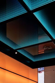 the interior of an office building is lit up with bright blue lights and shadows on the walls