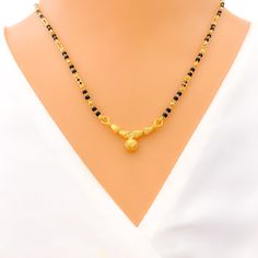 This Mangal Sutra, made with 22k yellow gold and weighing 8.3 grams, features a dazzling evergreen design. It's adorned with black beads, adding a classic touch to the piece. The necklace measures 16 inches in length with a drop of 0.3 inches, and it includes 0.6 inches of adjustable links for a customized fit. The hook lock ensures secure and comfortable wear. This Mangal Sutra is perfect for those who appreciate timeless elegance blended with a hint of modern allure. PRODUCT DETAILS Gold Purit Temple Style Necklaces With Black Beads For Festivals, Festive Temple Jewelry Necklace With Black Beads, Festive Black Temple Jewelry Necklaces, Festival Temple Jewelry Necklace With Black Beads, Festive Black Temple Jewelry Necklace, Gold Jewelry With Black Beads For Puja, Black Beads Jewelry For Puja And Festivals, Black Temple Jewelry Necklace For Diwali, Black Beaded Necklace For Diwali