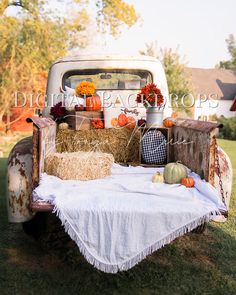 an old truck with hay and pumpkins in the back