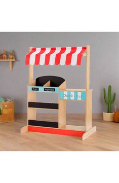 a wooden toy store with red and white awning