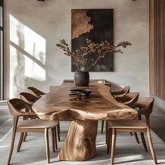 This dining room highlights a live-edge wooden dining table that showcases natural wood grain and organic form. The table pairs beautifully with wooden chairs featuring woven seats, creating a warm atmosphere. Decor includes a vase of branches and a bold abstract painting, combining natural materials and artistic accents for a balanced, earthy aesthetic perfect for those seeking a stylish wood-focused space. Wabi Sabi Dining Room, Scandinavian Dining Room, Organic Furniture, Live Edge Dining Table