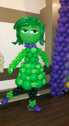 the balloon sculpture is made to look like a girl with green hair and purple pants