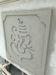 an ornate carving on the side of a wall in a room with construction materials around it