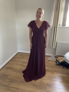 a woman standing in a room wearing a long dress