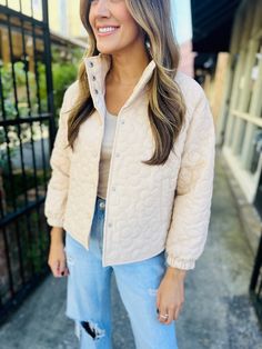 This cute beige jacket boasts a charming floral quilted pattern and playful button down style. Stay cozy and stylish in this unique piece! Fit: True to size. Fabric: 100% polyester Cream Button-up Outerwear With Snap Buttons, Cream Quilted Outerwear For Spring, Cream Quilted Long Sleeve Outerwear, Casual Beige Quilted Puffer Jacket, Cream Quilted Spring Outerwear, Spring Cream Quilted Outerwear, Beige Quilted Outerwear For Fall, Quilted Beige Outerwear For Spring, Trendy Quilted Beige Outerwear