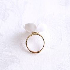 The beautiful plum blossom, who never fears frost and snow, bravely flowers in the coldest seasons, awakening spring and bringing hope. The pure and delicate petals deserve your extra love and care. Ring is made of porcelain flower; gold-plated silver ring and a small freshwater pearl. Material: Handmade porcelain plum blossom; Gold-plated silver ring; Small freshwater pearl. Gold- or silver-plated colour will fade over time. This is a normal result from long-term wear and contact with air. Howe Delicate White Proposal Ring, Delicate White Rings For Proposal, Delicate White Ring For Proposal, Delicate White Jewelry For Proposal, White Flower Ring For Promise, Adjustable White Flower Promise Ring, Delicate White Flower Ring For Wedding, Nature-inspired White Wedding Jewelry, Nature-inspired White Jewelry For Wedding