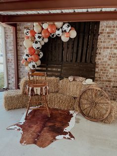 a room with hay bales and balloons in the shape of soccer balls on it