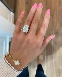 a woman's hand with pink manicures and a diamond ring