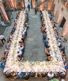 an aerial view of a long table with people sitting at it