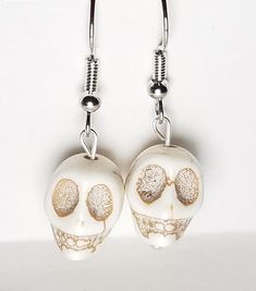 A pair of earrings made using skull beads. Perfect for Halloween! Each earring measures approximately 1.5 inches from top of earring wire to bottom of beads. Each pair comes with 2 earring backs. White Drop Earrings For Halloween, Gold Skull-shaped Earrings, Gold Skull Earrings Nickel Free, Nickel-free Bone Dangle Earrings, Nickel-free Bone-colored Dangle Earrings, Nickel Free Bone Color Dangle Earrings, Adjustable Beaded Earrings For Halloween, Bone Color Dangle Earrings With Ear Wire, Halloween Skull Jewelry With Ear Wire