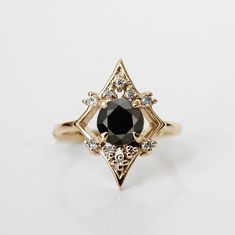 a black diamond sits on top of a gold ring with small diamonds around the band