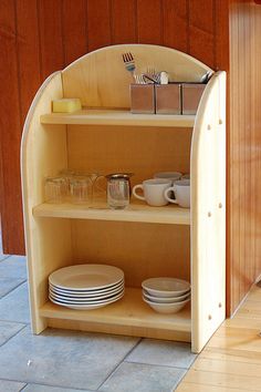 a wooden shelf with plates and cups on it