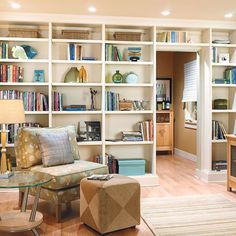 a living room filled with lots of furniture and bookshelves covered in shelves full of books