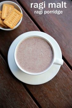 a cup of hot chocolate next to crackers on a wooden table with text overlay that reads ragi malt ragi porridge