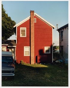 a truck parked in front of a red house