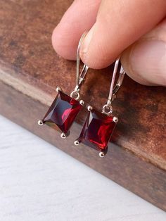 Garnet Earrings, January Birthstone, Dark Read Emerald Cut Earrings in Gold or Silver, Rectangular Baguette Drops, Garnet Jewelry for Women These elegant baguette earrings feature dark red rectangle gemstones prong set in your choice of gold filled or sterling silver. The vivid garnet emerald cut drops are suspended from lever back ear wires in the finish of your choice. These are great choice for simple yet elegant earrings to wear virtually anywhere. Ideal gift for a woman born in January, as Red Sterling Silver Earrings For Evening, Red Faceted Drop Earrings, Red Sterling Silver Evening Earrings, Red Faceted Earrings For Anniversary, Red Faceted Earrings For Formal Occasions, Classic Rectangular Stone Earrings For Gift, Classic Earrings With Rectangular Stone For Gift, Classic Rectangular Stone Earrings As Gift, Elegant Red Crystal Earrings Nickel Free