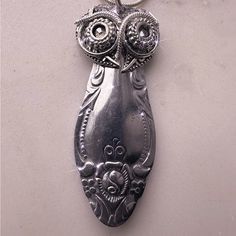 an owl shaped pendant is hanging from a chain