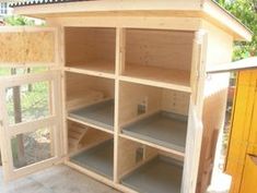 a chicken coop built into the side of a house with windows and shelves on each side