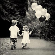 two children holding hands and flying balloons with the words, everytime i see you fall in love all over again