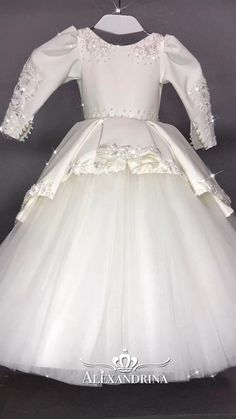 The classic dress "Yasmin" is made in white color with a small tulle train and an elegant peplum on the skirt which is decorated with lace, pearls and beads. The V-back is embroidered with floral lace. The shoulders of the dress are embroidered with lace and decorated with decorative elements. The belt is also embroidered with a scattering of stones. Sleeves with a graceful cut, closed with a stunning lace applique with beads, are especially delightful! Tulle Train, Dresses 2022, Decorative Elements, Flower Girl Dress, Classic Dress, Lace Pattern, Lace Applique, Real Pictures, Girl Dress