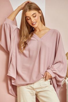 This blouse is out to prove that comfy and chic can coexist in perfect harmony. Its flowy, dolman cut gives you room to breathe while still maintaining a flattering drape. 3/4 sleeves keep it seasonal, transitioning effortlessly from summer to fall. A plunging V-neckline shows just enough skin to be subtly seductive, but the blush pink hue is as sweet and charming as an English rose garden. In short, this top lets you make a stylish statement without having to sacrifice one ounce of comfort. It’ Versatile Spring Tops With Batwing Sleeves, Spring Versatile Batwing Sleeve Top, Versatile Oversized V-neck Blouse, Oversized Versatile V-neck Blouse, Oversized Half Sleeve Blouse For Fall, Versatile Batwing Sleeve Tops For Spring, Oversized Half-sleeve Blouse For Fall, Chic Batwing Sleeve Blouse With Relaxed Fit, Chic Blouse With Batwing Sleeves And Relaxed Fit