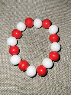 A simple, fun bracelet made with red and white wooden beads on a nylon stretch cord. With 8 beads of each color, this bracelet is made to look like the one worn by Kyo Sohma in the Fruits Basket manga and anime. Kyo's bracelet is a set of juzu beads, or Buddhist prayer beads. Kyo's Bracelet, Handmade White Plastic Beaded Bracelets, White Plastic Stretch Bracelet As Gift, White Plastic Beaded Bracelets, Adjustable Red Beaded Plastic Bracelets, Casual White Stretch Bracelet With Wooden Beads, Red Plastic Beaded Bracelets As Gift, White Plastic Beaded Bracelets For Friendship, White Wooden Beads Stretch Bracelet As Gift