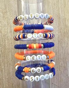 Show off your Houston Astros pride with these custom Heishi bracelets, designed in the team's signature colors--navy blue, orange, and white! Each bracelet is handcrafted with high-quality Heishi beads, creating a stylish and lightweight accessory perfect for any fan. Whether you're heading to the game or just want a pop of team spirit in your everyday look, these bracelets are the perfect addition to your Astros collection. Available in various sizes and customizable with initials, names or slo Personalized Blue Bracelets For Game Day, Blue Team Spirit Beaded Bracelets As Gift, Blue Beaded Bracelets With Letter Beads For Team Spirit, Blue Beaded Bracelets For Team Spirit Gift, Blue Adjustable Beaded Bracelets For Team Spirit, Casual White Stacked Bracelets, White Stacked Casual Bracelets, Blue Adjustable Bracelets For Team Spirit, Sporty White Beaded Bracelets For Friendship