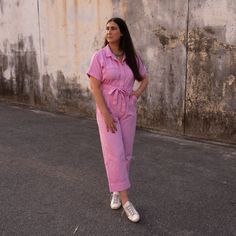 Description: This playful pink denim jumpsuit is the perfect balance between casual comfort and summer chic. Its structured yet relaxed fit flatters the figure, while the bright hue adds a pop of fun to any wardrobe. Ideal for daytime outings or laid-back evenings, this jumpsuit pairs effortlessly with white sneakers for a classic look, making it a must-have for those who love to blend style with ease. Model is 5'9" and has a 36" bust and 29" waist. Wearing a size Large. Summer Cotton Jumpsuits And Rompers With Short Sleeves, Summer Jumpsuits And Rompers With Short Sleeves Relaxed Fit, Summer Pink Jumpsuits And Rompers With Pockets, Casual Short Sleeve Jumpsuits And Rompers For Day Out, Spring Cotton Jumpsuits And Rompers For Loungewear, Chic Cotton Denim Jumpsuit With Relaxed Fit, Relaxed Fit Denim Jumpsuit Overall For Day Out, Casual Pink Overalls For Spring, Casual Pink Jumpsuits And Rompers With Pockets