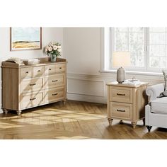 a living room scene with focus on the dresser and chair next to the couch,