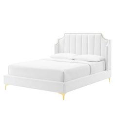 a white bed with gold trimmings on the headboard and foot board, in front of a white background