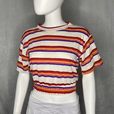 This groovy short sleeve features rainbow stripes top to bottom, and a cinched hem around the waist. 70% Cotton 20% Polyester 10% Rayon Model is wearing a size S Trendy Rainbow Top For Pride, Multicolor Short Sleeve Tops For Pride, Pride Multicolor Short Sleeve Tops, Casual Multicolor Tops For Pride, Trendy Striped Rainbow Print Tops, Trendy Rainbow Print Striped Tops, Striped Rainbow Print T-shirt For Spring, Trendy Striped Tops With Rainbow Print, Spring Striped T-shirt With Rainbow Print