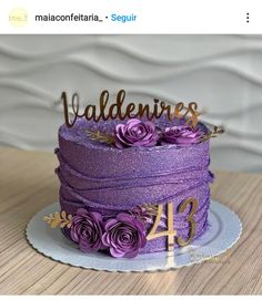 there is a purple cake with flowers on it