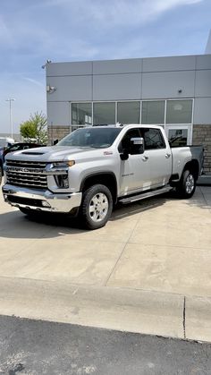 a silver truck parked in front of a building