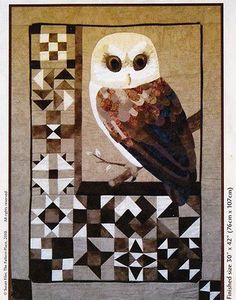 an owl is sitting on top of a quilt