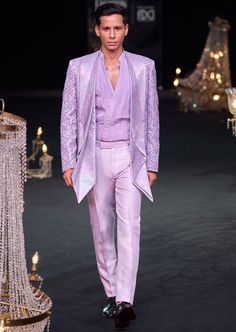 Elevate your evening ensemble with our expertly crafted three-piece tuxedo set. Crafted on a glamorous shimmer base. This lavender tuxedo is ornate with hand embroidered cutdana work and lapel detailing. Complemented with a pleated shirt and straight pants. This glitzy outfit will command everyone's attention. Dry-clean only if required. Slight variation in color is possible due to digital photography. Luxury Sequin Party Sets, Luxury Fitted Evening Sets, Luxury Fitted Evening Set, Tailored Tuxedo Sets For Gala, Luxury Sequined Party Sets, Elegant Sequined Suits For Evening, Fitted Party Wear Sets For Gala, Elegant Festive Set For Gala, Fitted Sets For Gala Party Wear