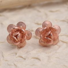 Tiny blossoms twinkle in warm rose gold in these hand crafted button earrings from Bali's Yuniati. Designed from 18k rose gold plated sterling silver filigree these enticing earrings are hand crafted with coin-shaped petals and completed with a combination finish. Formal Rose Gold Earrings With Rose Design, Formal Rose Gold Flower Earrings, Rose Gold Flower Charm Earrings, Rose Gold Round Flower Charm Earrings, Round Rose Gold Flower Charm Earrings, Rose Gold Flower-shaped Jewelry With Matching Earrings, Sterling Silver Rose Designed Rose Gold Earrings, Rose Gold Pierced Flower Earrings For Formal Occasions, Rose Gold Flower Shaped Pierced Earrings