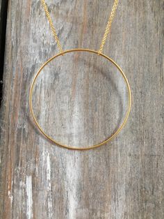 "Handmade necklace consisting of a large single circle strung from a delicate chain. The chain shown is 18\", but custom lengths are welcomed. Available in silver and gold. This unique necklace is perfect for anyone loves accessorizing with on trend, modern or minimalist jewelry. Made from high quality 16k gold plated brass. It has an effortless chic vibe to it and is great for layering. All jewelry is lovingly made in Massachusetts and ships profesionally packaged in an attractive box, ready to Minimalist Round Charm Necklace With Chain, Minimalist Round Charm Necklaces With Chain, Minimalist Metal Necklace With Cable Chain, Gold Circular Jewelry With Cable Chain, Minimalist Long Chain Necklace, Delicate Circle Chain In Yellow Gold, Dainty Delicate Chain Jewelry, Minimalist Metal Cable Chain Necklace, Yellow Gold Jewelry With Delicate Circle Chain