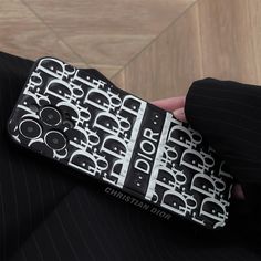 a person in a suit holding a cell phone with an elephant pattern on the cover