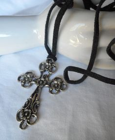 "Here we have a vintage pierced silver metal floral design cross necklace. This is 2 3/8\" by 1 5/8\" at the widest point. Has a WR mark on the back and there is a nice weight to it. Comes with just a black cord and not tied for length. Please look at pictures, this is a used vintage item. PLEASE convo me with any questions. Please check out my other items. Thanks for looking Elvira" Black Vintage Jewelry, Vintage Adjustable Cross Pendant Necklace, Adjustable Vintage Cross Pendant Necklace, Vintage Metal Cross Pendant Necklace, Vintage Metal Crucifix Cross Necklace, Handmade Vintage Style Cross Necklace As Gift, Handmade Vintage Cross Necklace Gift, Handmade Vintage Cross Necklace As Gift, Handmade Vintage Cross Necklace For Gift