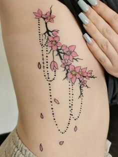 a woman's stomach with pink flowers and beads on the bottom part of her body