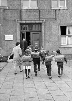 an old black and white photo of people walking in front of a building with mail bags