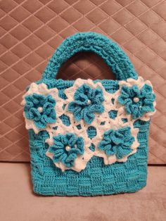 Cute little handbag. Crocheted from blue good quality acrylic yarn. Flowers also are made from acrylic yarn and pearl white beads. Inside is small waterproof zipped bag with 3 pockets. L*W*H --> 26*8*37 Depth 20 cm Made in a smoke free home. Is ready to use and ready to ship! Blue Knitted Shoulder Bag For Daily Use, White Knitted Rectangular Shoulder Bag, Handmade Blue Crochet Bag For Daily Use, Blue Handmade Crochet Bag For Daily Use, Handmade Blue Pouch Shoulder Bag, White Hand Knitted Tote Bag, White Hand-knitted Tote Bag, Hand Knitted Blue Shoulder Bag For Daily Use, Blue Hand Knitted Rectangular Shoulder Bag