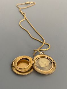 "Weight: 11.9g Dimensions: 1\" round, 18\" chain Hallmarks: Makers mark L & M Although these lockets were patented in the year 1902, this particular locket states on its backside that it is from the 'class of '12' dating it to a decade later. This is a very unique locket in that it has 3 windows and folds like an accordion. All bezels are present and the two clear windows inside the front and back covers are still present. The locket measures 1\" round and comes on an 18\" GF chain. Very lig Victorian Style Medallion Coin Pendant Jewelry, Antique Medallion Locket Necklace Stamped 14k, Antique Yellow Gold Medallion Locket Necklace, Antique Style Yellow Gold Medallion Locket Necklace, Antique Coin Pendant Necklace, Antique Oval Coin Pendant Necklace, Victorian Round Locket Necklace Stamped 14k, Antique Necklace With Oval Coin Pendant, Yellow Gold Medallion Locket Necklace