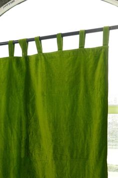 a green curtain is hanging in front of a window