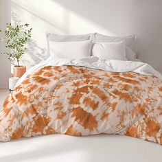 an orange and white comforter on a bed